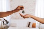 Real estate agent giving a man the keys to his new home - offer to purchase concept